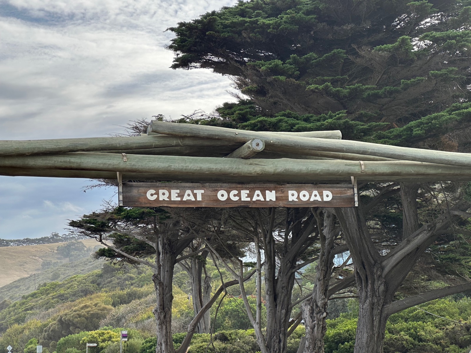 Wooden sign with white text saying 'Great Ocean Road'.